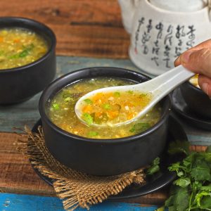 side close up shot of sweet corn soup in a bowl with a soup spoon