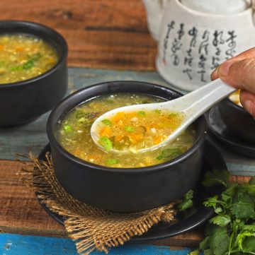 side close up shot of sweet corn soup in a bowl with a soup spoon