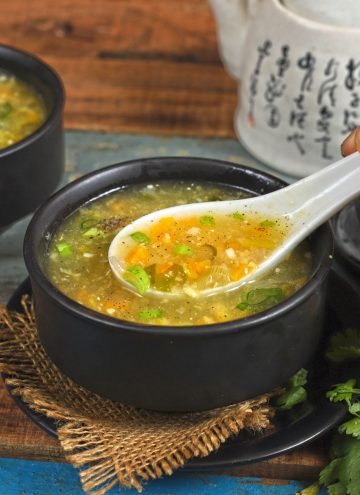 side close up shot of sweet corn soup in a bowl with a soup spoon
