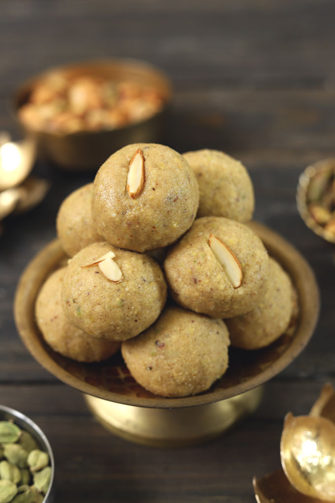 side shot of stacked atta ladoo on a golden platter