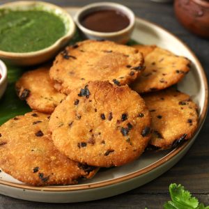 side close up shot of maddur vada stacked on a ceramic platter