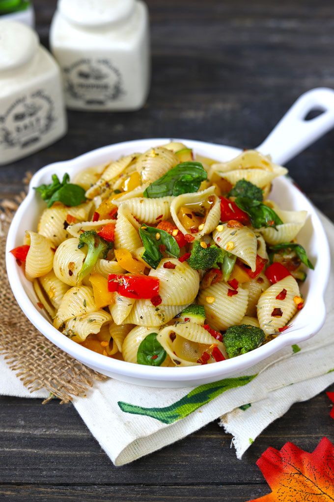 side shot of stir fry pasta with vegetables in a white pan