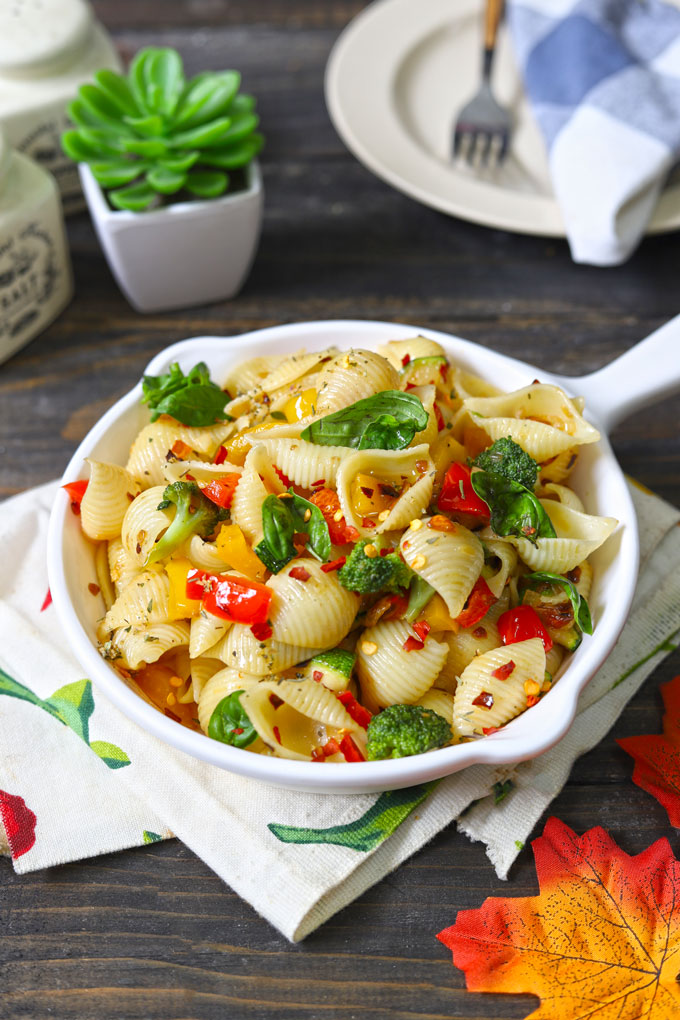 side shot of stir fry pasta with vegetables in a white pan