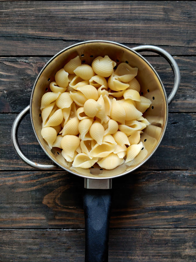 aerial shot of boiled shell pasta on a metal colander