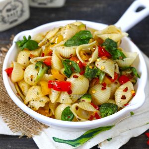 side close up shot of stir fry pasta with vegetables on a white pan