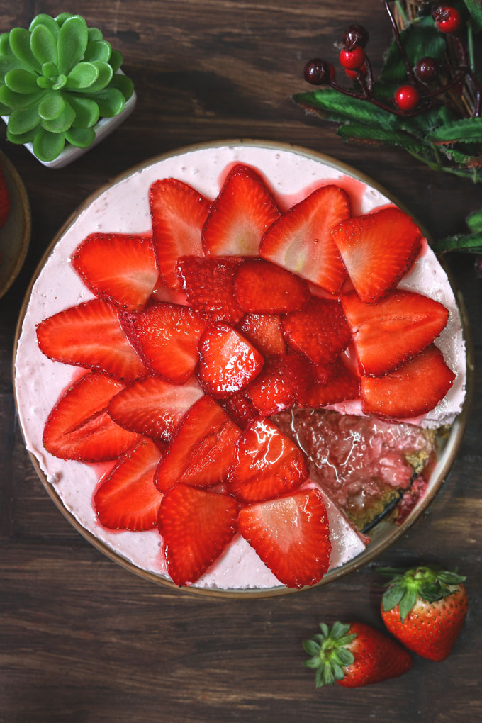 aerial shot of sliced strawberry cheesecake on a cream platter