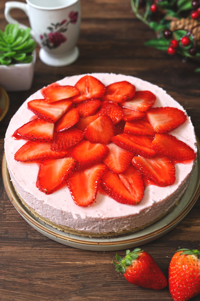 side close up shot of no bake strawberry cheesecake on a round platter