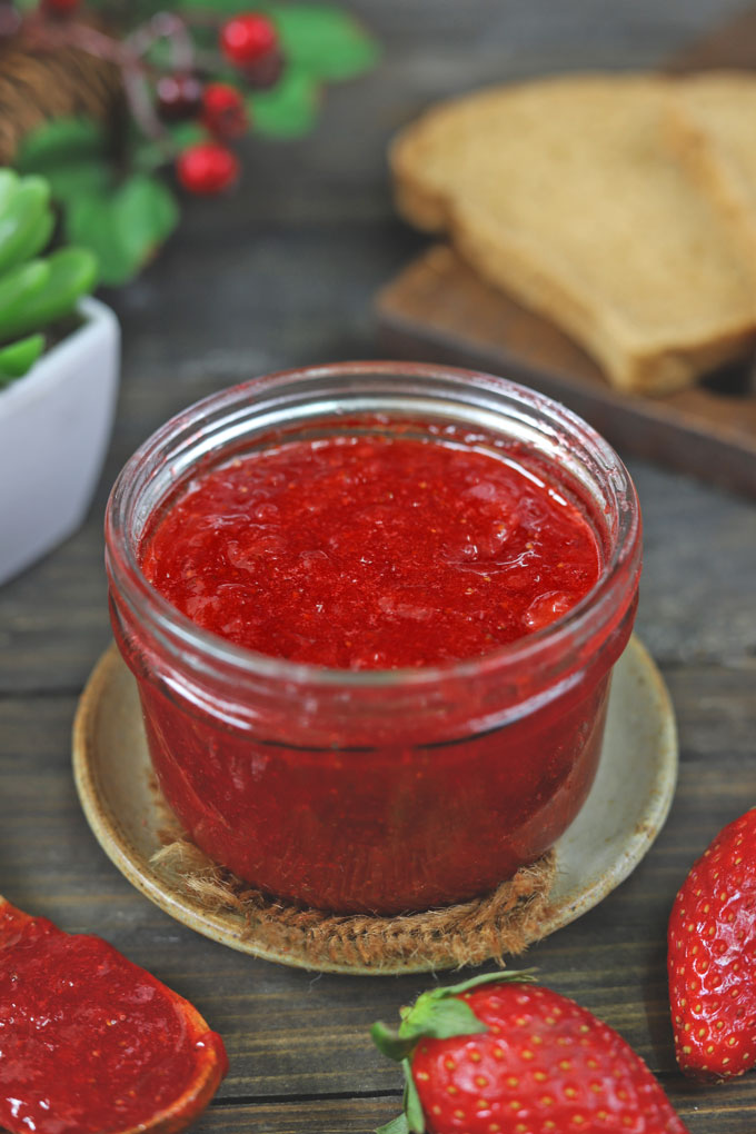 side shot of strawberry jam in a glass jar 