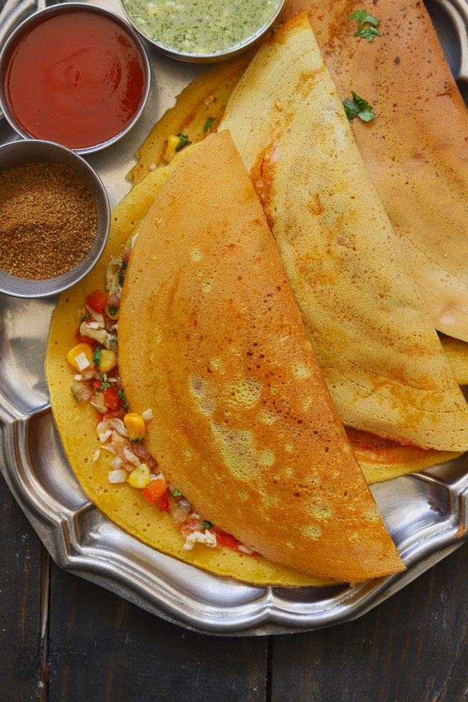 aerial shot of besan chilla stacked on a steel platter