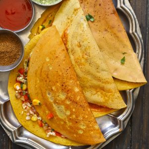 aerial shot of besan ka chilla stacked on a steel platter