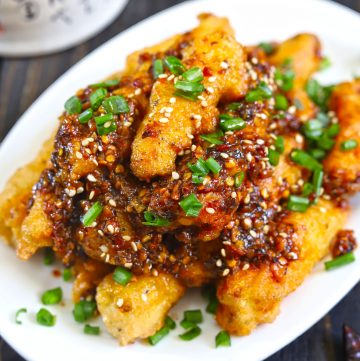 side close up shot of crispy baby corn stacked on a white platter