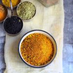 aerial shot of homemade achar masala in a black ceramic bowl