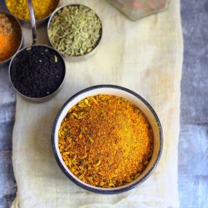 aerial shot of homemade achar masala in a black ceramic bowl