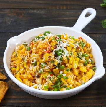 side shot of cheese chilli corn dip in a white pan