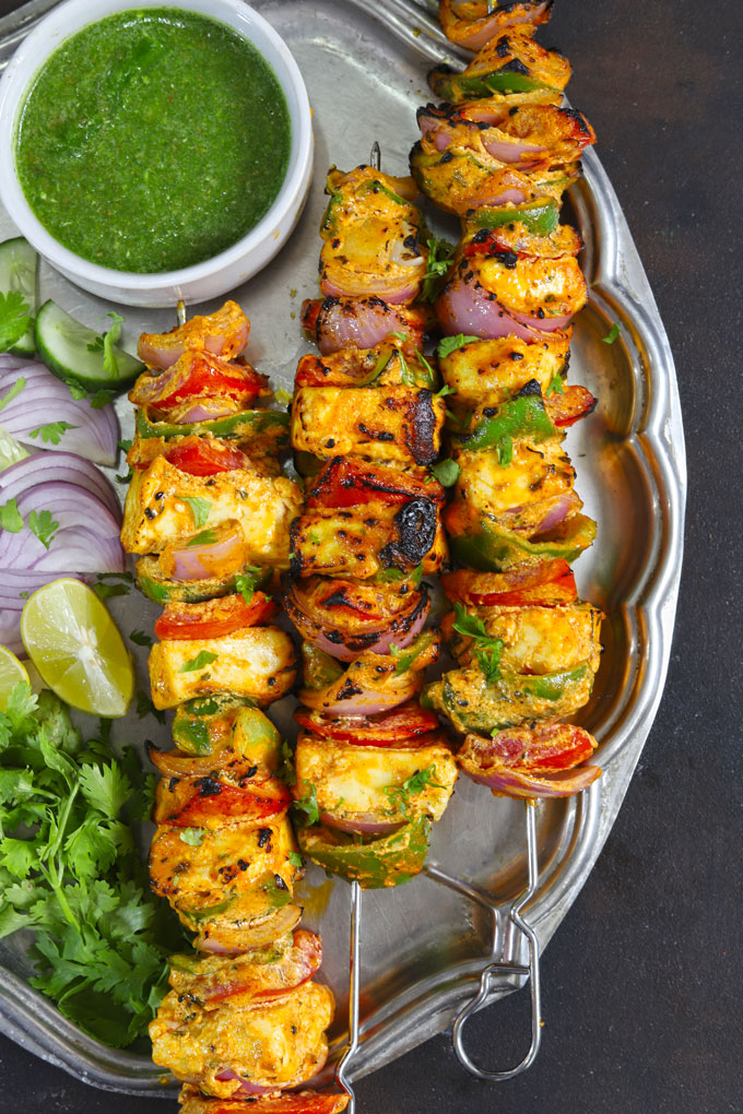 aerial shot of paneer tikka skewers stacked on a vintage platter