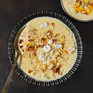 aerial shot of makhana kheer in a black ceramic bowl with a spoon