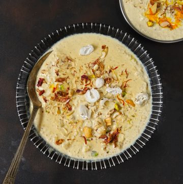 aerial shot of makhana kheer in a black ceramic bowl with a spoon