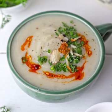 side shot of cauliflower soup in a green ceramic mug