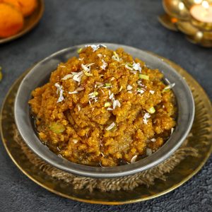 side close up shot of moong dal halwa in a black ceramic bowl