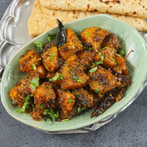 side shot of kaddu sabzi i a green ceramic bowl