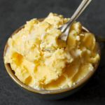 side close up shot of homemade butter in a bowl with a spoon
