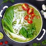 aerial shot of thai green curry soup in a white ceramic bowl