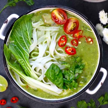 aerial shot of thai green curry soup in a white ceramic bowl