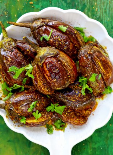aerial shot of achari baingan stacked in a white ceramic plate