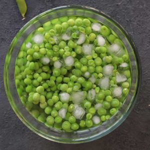 giving ice bath to blanched green peas