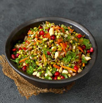 side shot of mung bean sprout salad in a black ceramic bowl