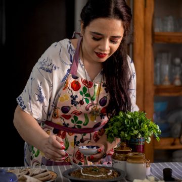 side shot of hina gujral cooking in her kitchen