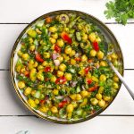 aerial shot of chickpea salad in a white ceramic bowl with a spoon