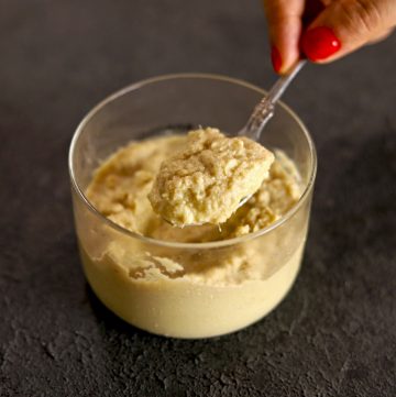 side shot of ginger garlic paste in a glass jar with a spoon