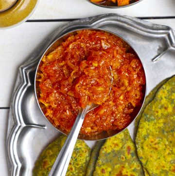 aerial shot of instant aam chunda in a stainless steel bowl with the spoon