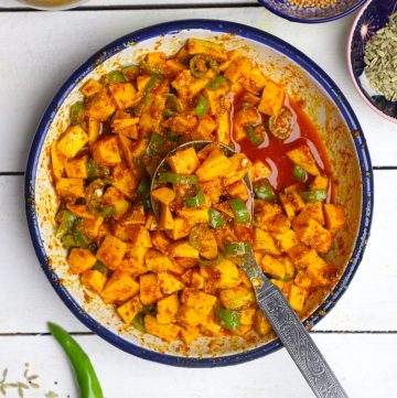 aerial shot of mango pickle in a white bowl with the spoon