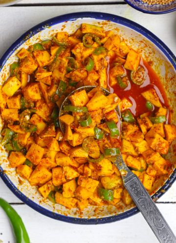 aerial shot of mango pickle in a white bowl with the spoon