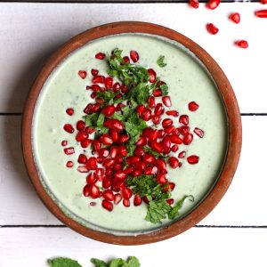 aerial shot of pomegranate mint raita in an earthen bowl