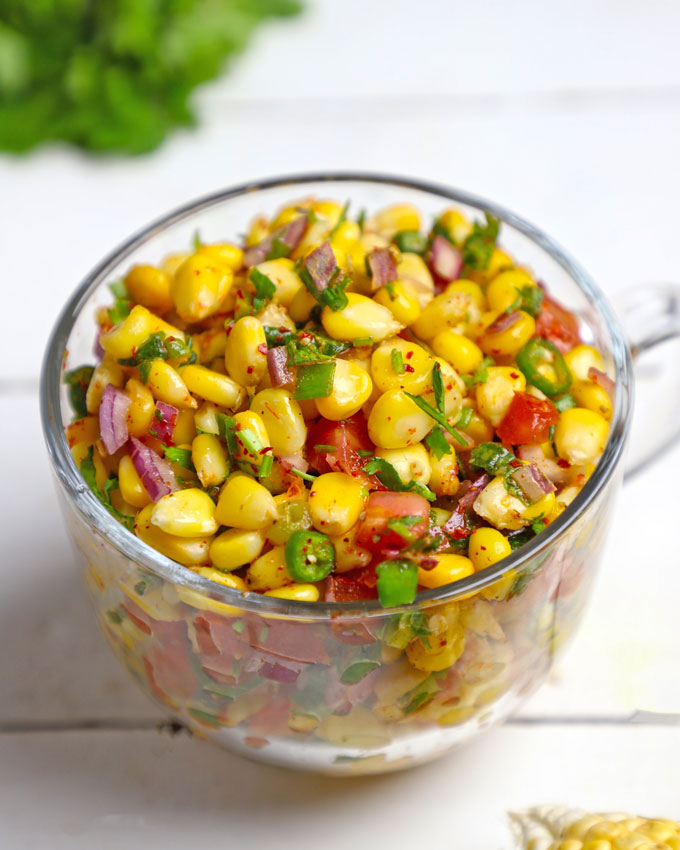 side shot of corn chaat in a glass mug