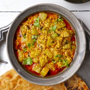 aerial shot of dahi lauki ki sabji in a black ceramic bowl