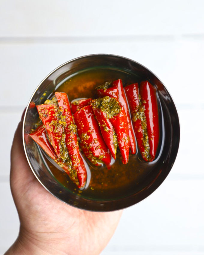 aerial shot of red chilli pickle in a stainless steel bowl