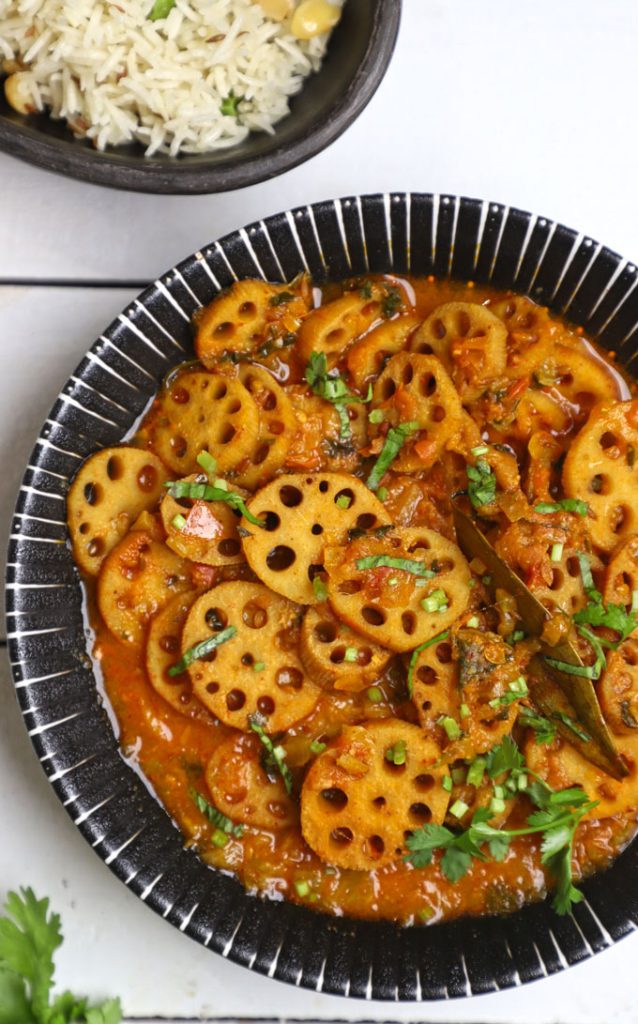 aerial shot of kamal kakdi ki sabji in a black ceramic bowl