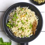 aerial shot of matar pulao in a black ceramic bowl