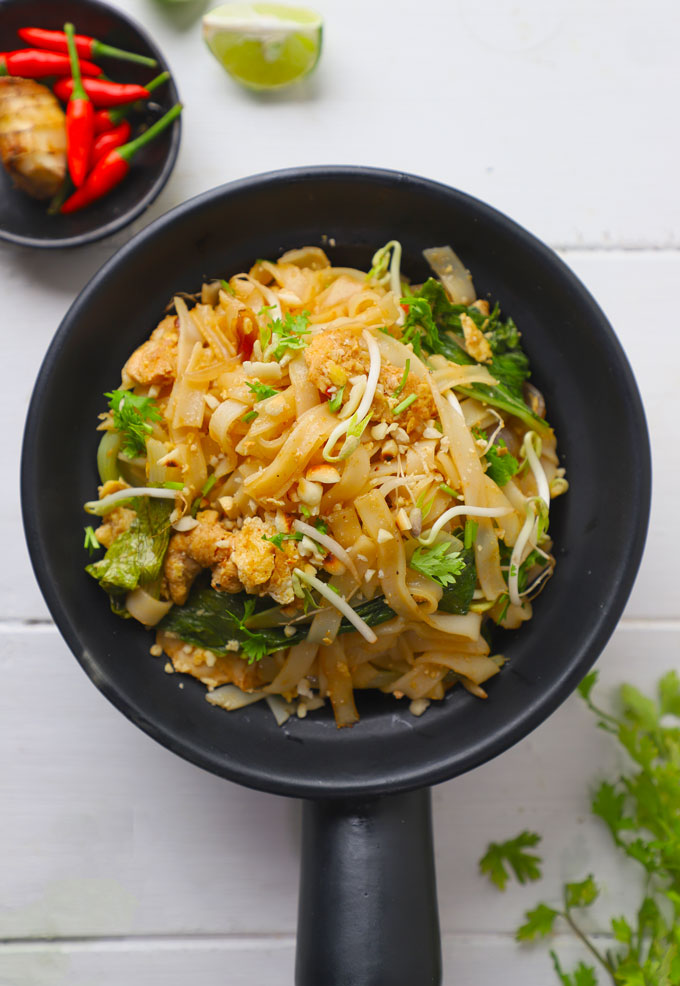 aerial shot of chicken pad thai in a black serving bowl
