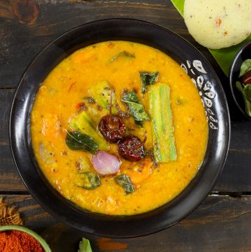 aerial shot of vegetable sambar served in a black ceramic bowl