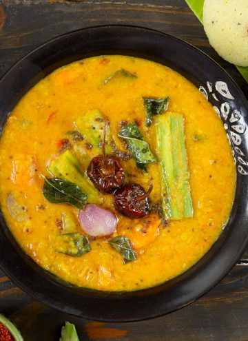 aerial shot of vegetable sambar served in a black ceramic bowl