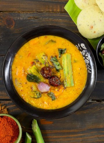 aerial shot of vegetable sambar in a black ceramic bowl