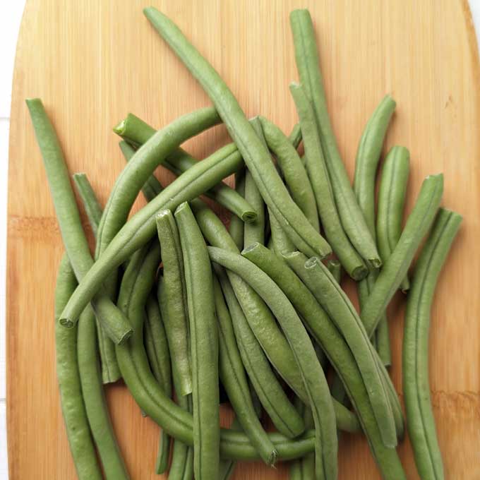 aerial shot of french green beans on a wooden chopping board