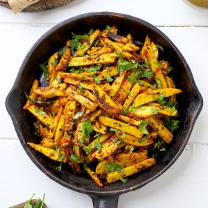 aerial shot of masala arbi fry in a black cast iron pan