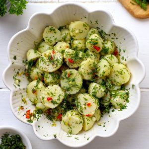 aerial shot of herbed potato salad in a white ceramic bowl