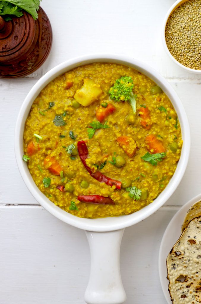 aerial shot of vegetable millet khichdi in a white ceramic pan